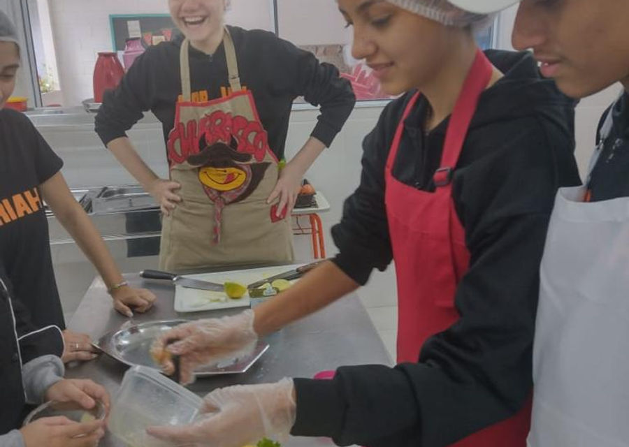 Alunos em atividade prática de culinária no ensino complementar